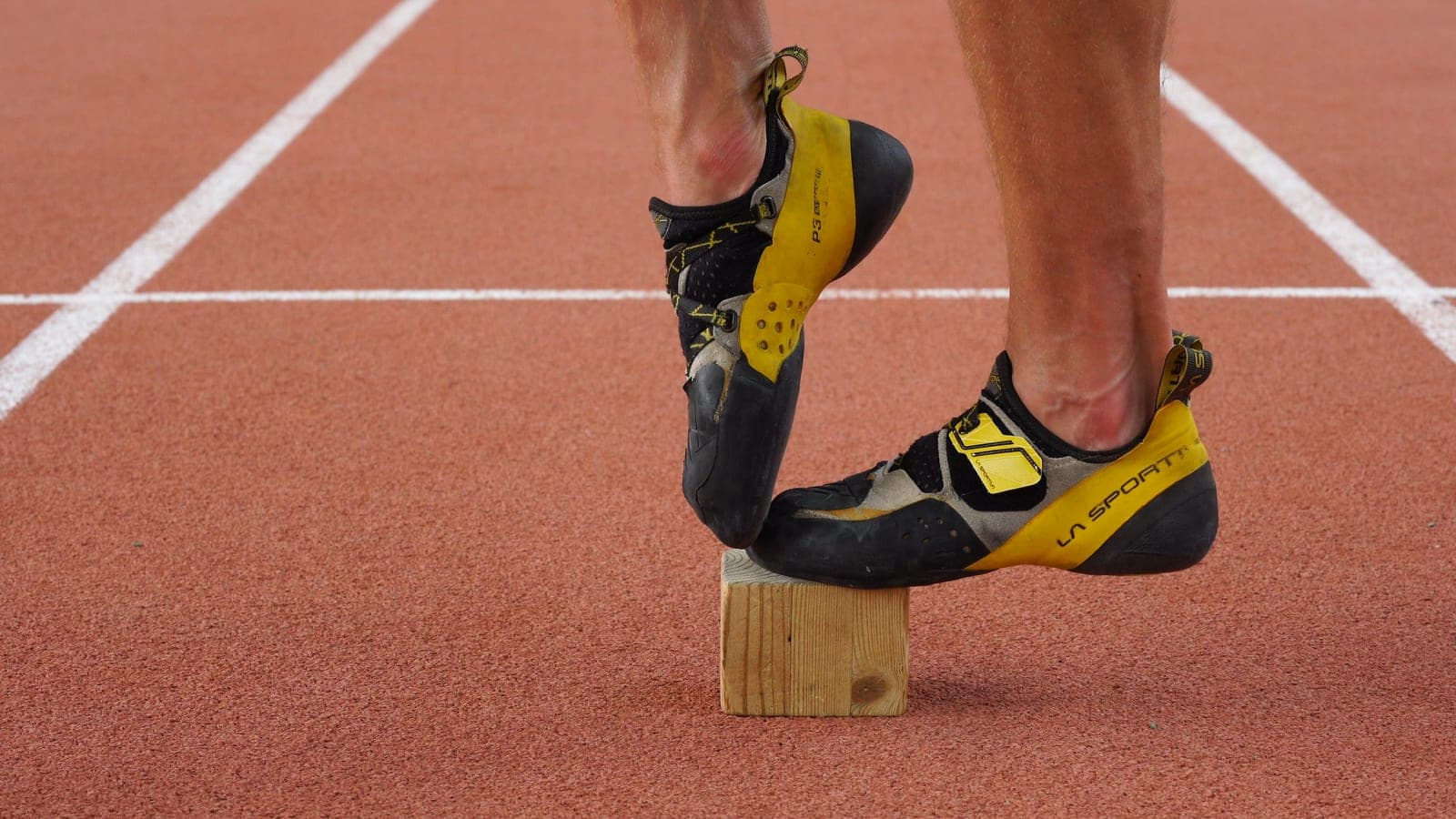 Climbing shoes balancing on a small wooden block, an off-the-wall footwork and balance drill.